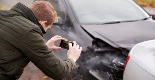 man taking photo of car accident